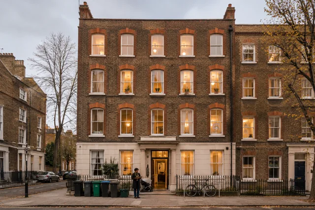 A housing officer and a family reviewing a tenancy agreement in a bright, self-contained flat recently reactivated from a vacant London building.